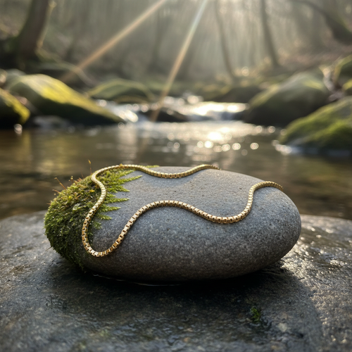 Delicate gold chain bracelet on river stone